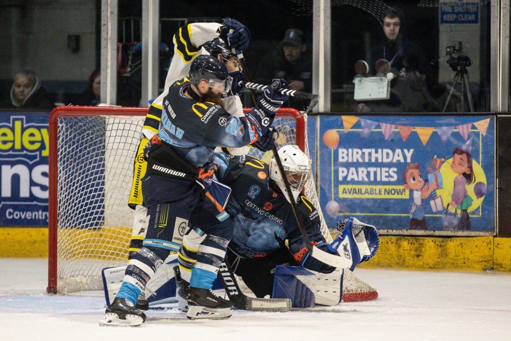 Stewart makes a save with Saucerman battling a Flyers forward in front of the net. 